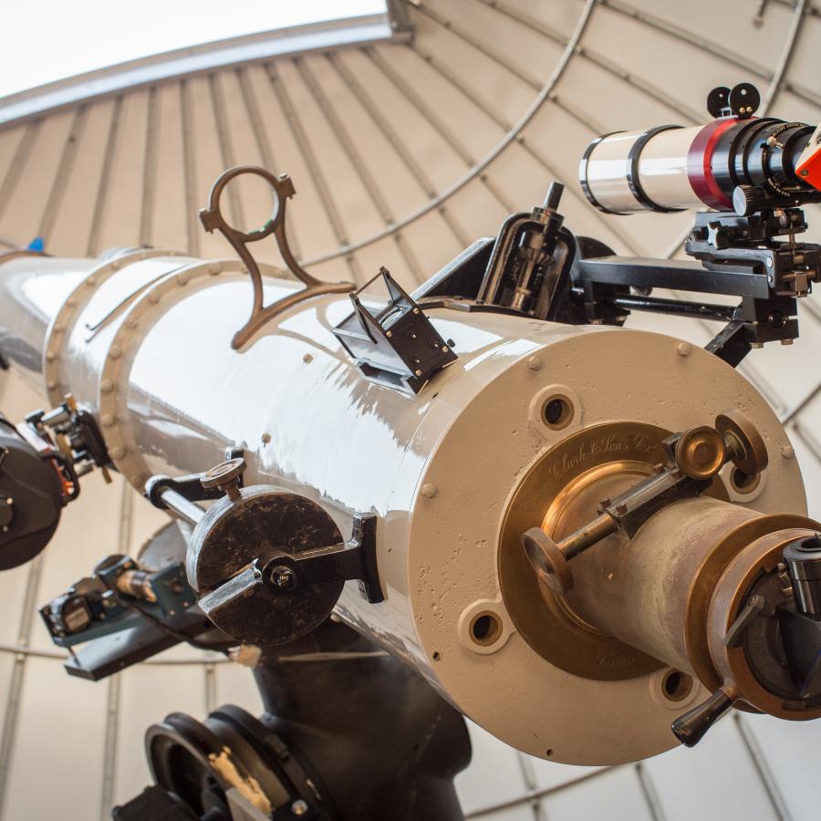 Large white telescope points towards the afternoon sky through an open observatory dome