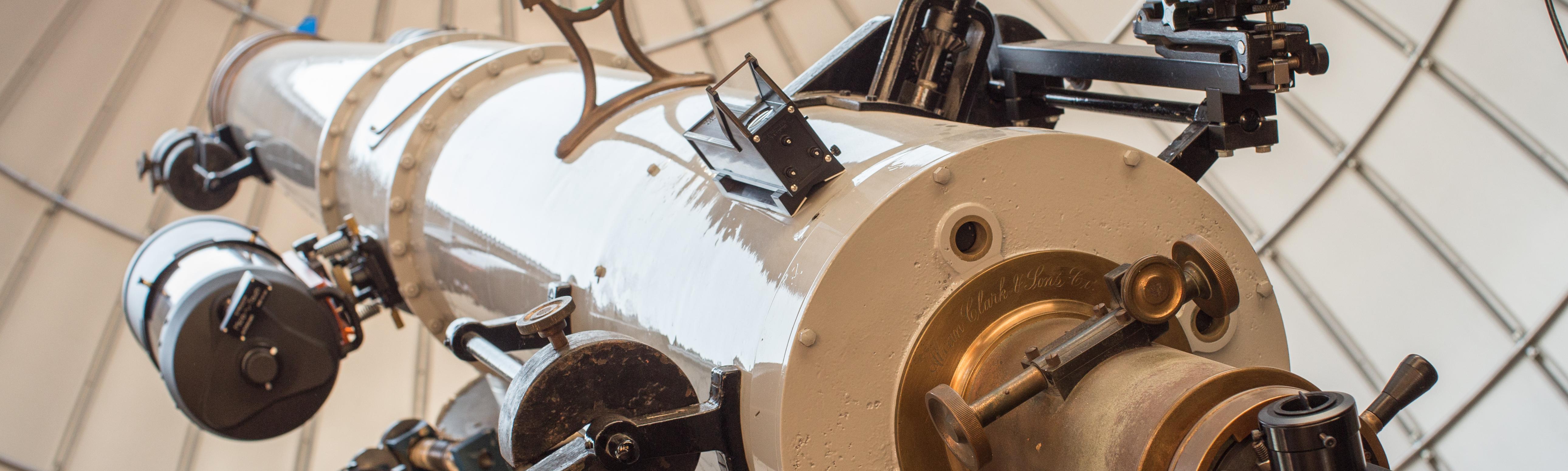 Large white telescope points towards the afternoon sky through an open observatory dome