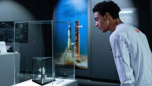 Individual looking at some moon rock inside of a glass case