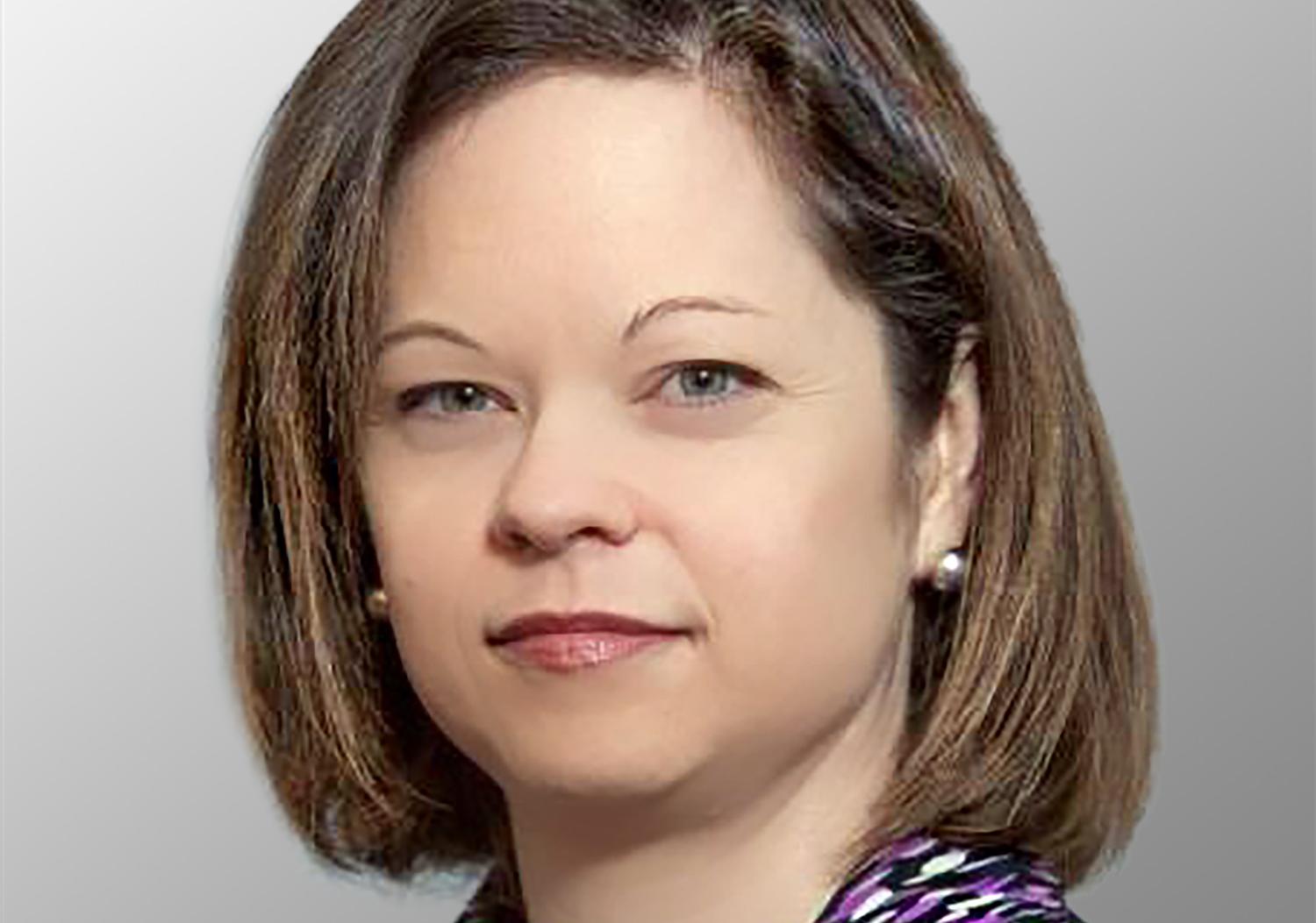 Head shot of a female with brown chin length hair wearing a purple shirt and black suit coat