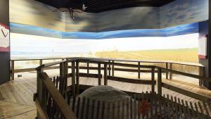 Wooden walkway in foreground with area behind it painted to appear like a lowcountry South Carolina beach