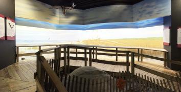 Wooden walkway in foreground with area behind it painted to appear like a lowcountry South Carolina beach