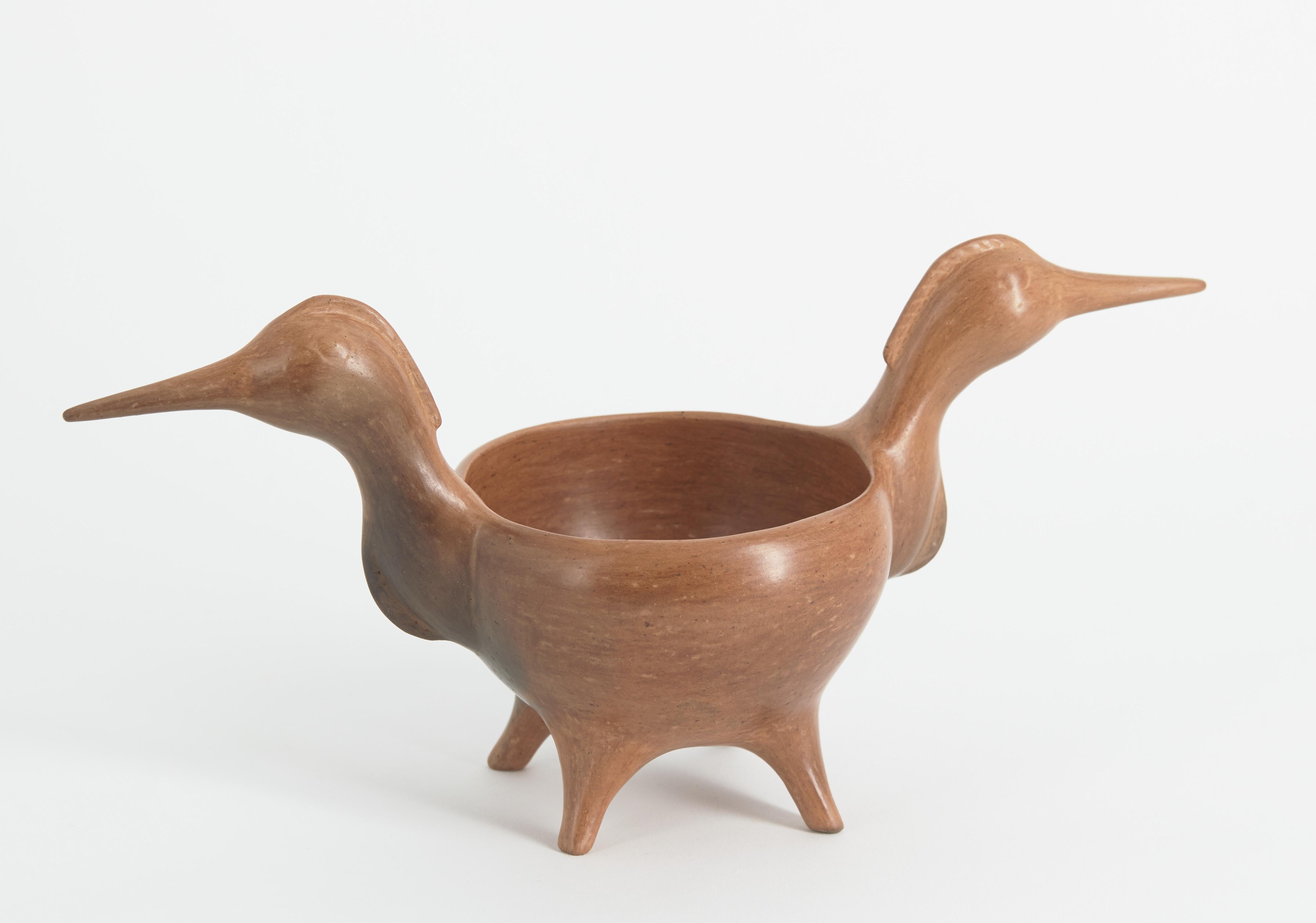 Black and light grey wedding jug with a short basket handle that connects two long necks with elongated narrow spouts. The jug is decorated with incised feather forms on both sides with a single feather on the bowl that splits into two feathers along each spout.