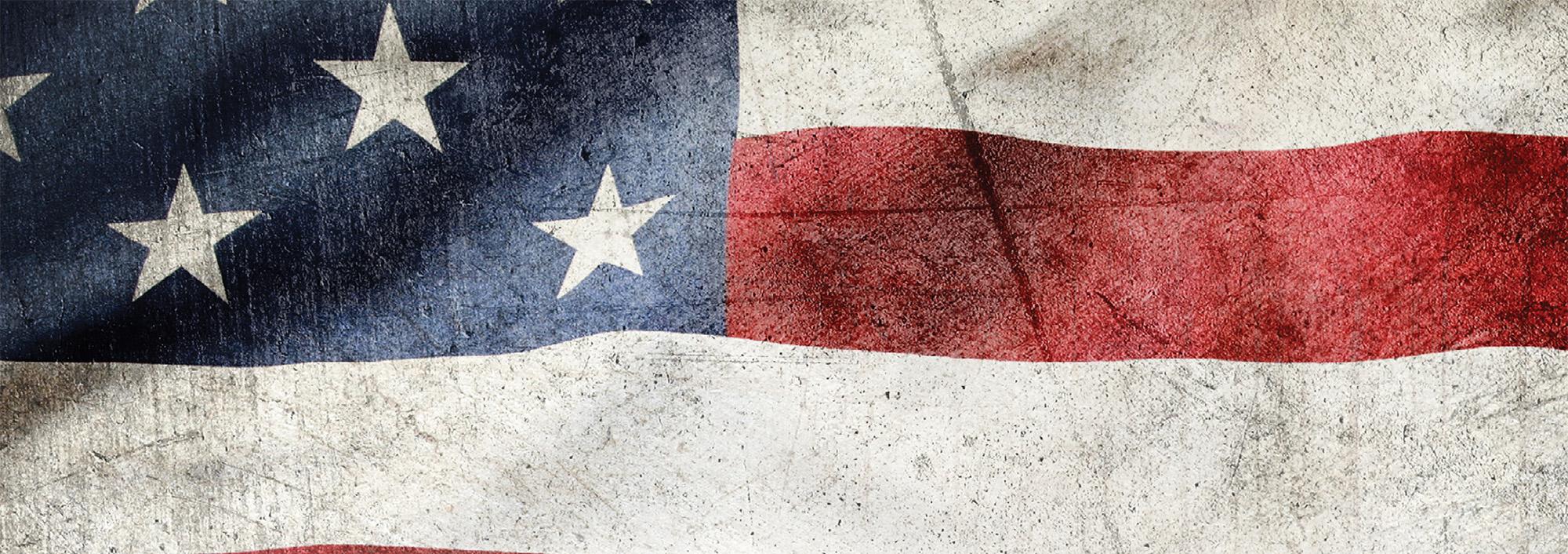 Close up color photo showing flag with red and white stripes and white stars on a blue field