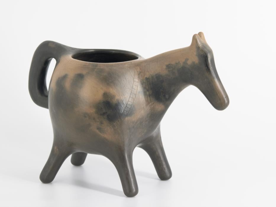 Tan pipe bowl shaped like an Indian head, with some black coloration on the face and side.