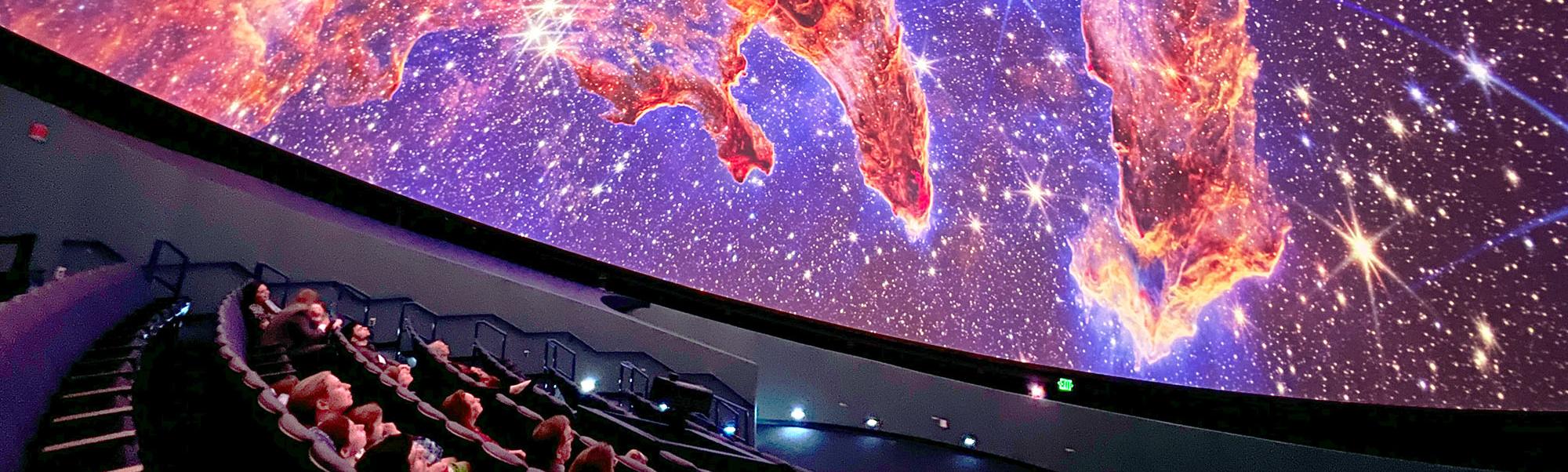 Guests in the planetarium dome look up at projection of the Pillars of Earth on the planetarium dome