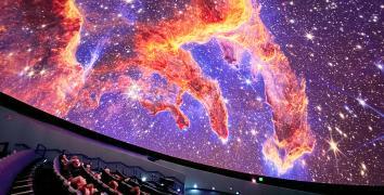 Guests in the planetarium dome look up at projection of the Pillars of Earth on the planetarium dome