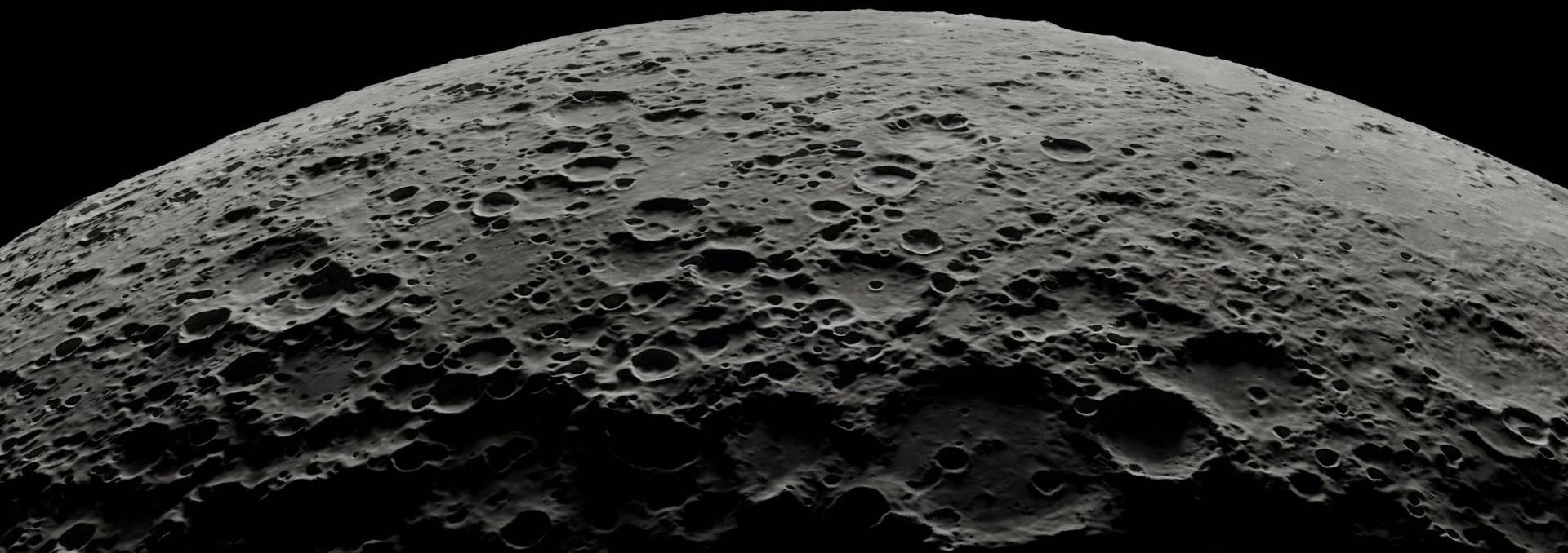 Close up of dark gray cratered surface of the moon 