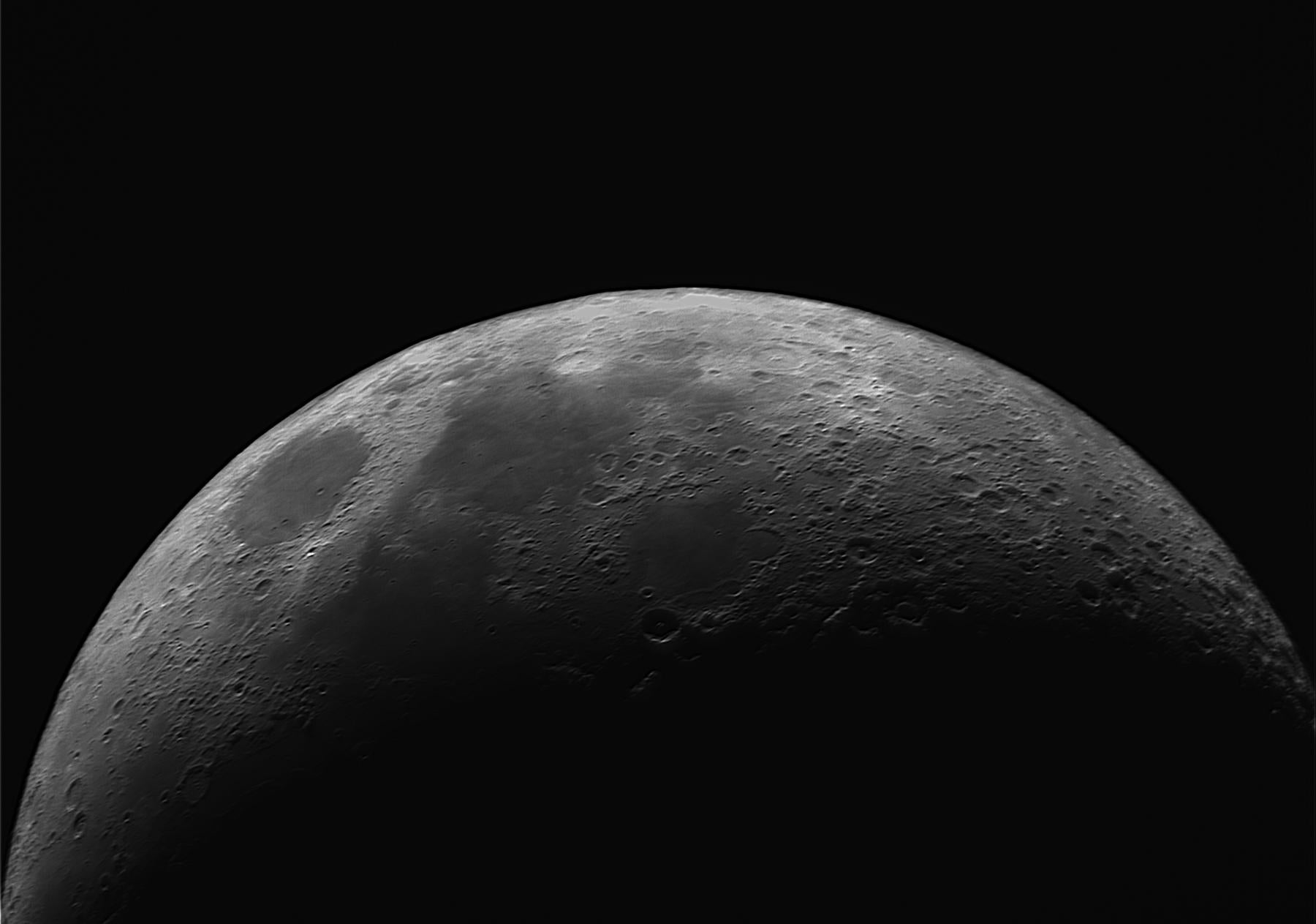 Top half on Moon with visible craters against the blackness of space