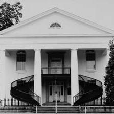 Black and white image of two story house with large iron staircase