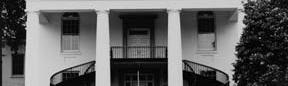 Black and white image of two story house with large iron staircase