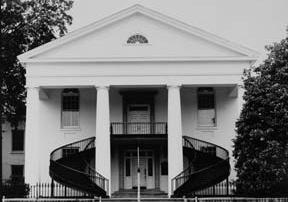 Black and white image of two story house with large iron staircase
