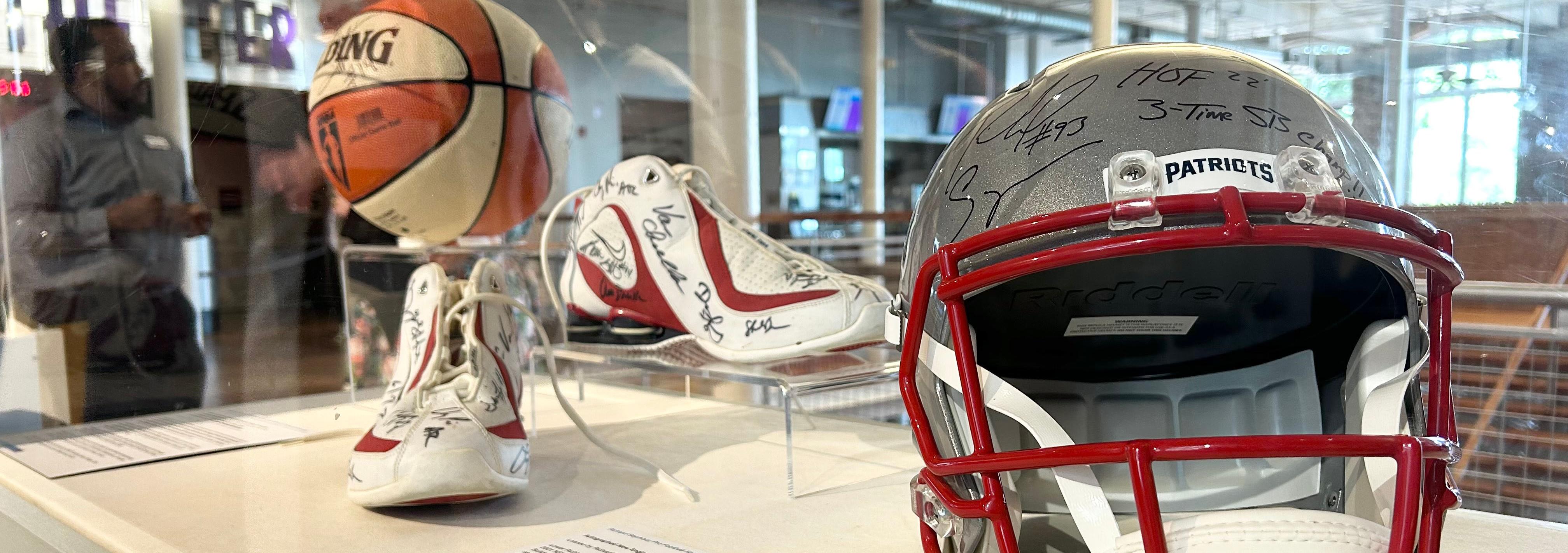 Display case with football helmet and a pair of sneakers inside