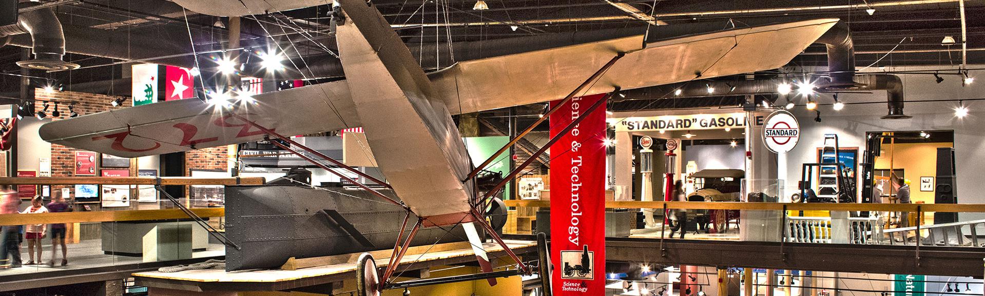 SC State Museum 4th floor exhibit gallery looking down onto the 3rd floor galleries with Clemson plane suspended from ceiling in foreground