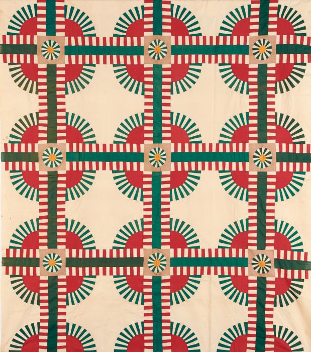 Cream colored quilt with 3-up motif on red circles bordered in radiating outward green dashes that are cross cute with solid green lines trimmed in red dashes.