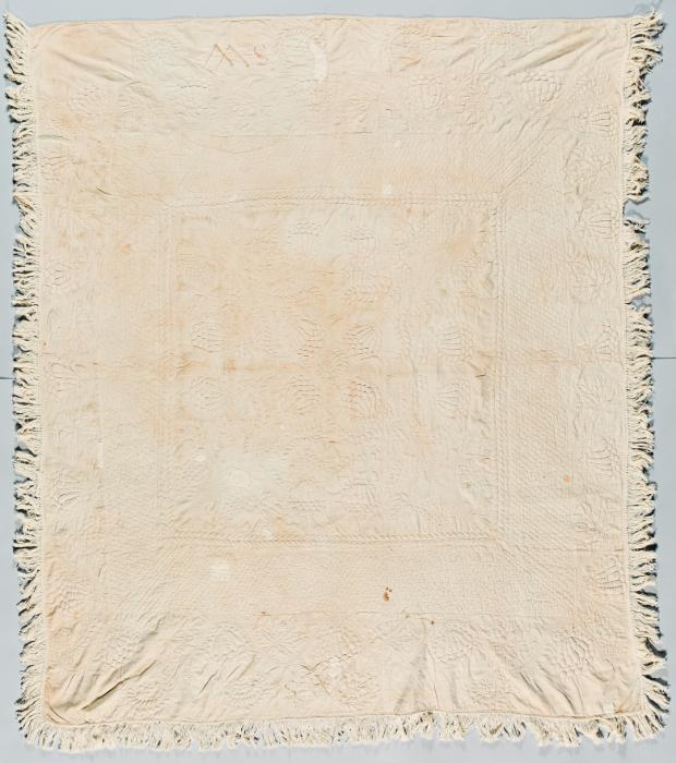 Whitework coverlet with embossed designs and fringed border