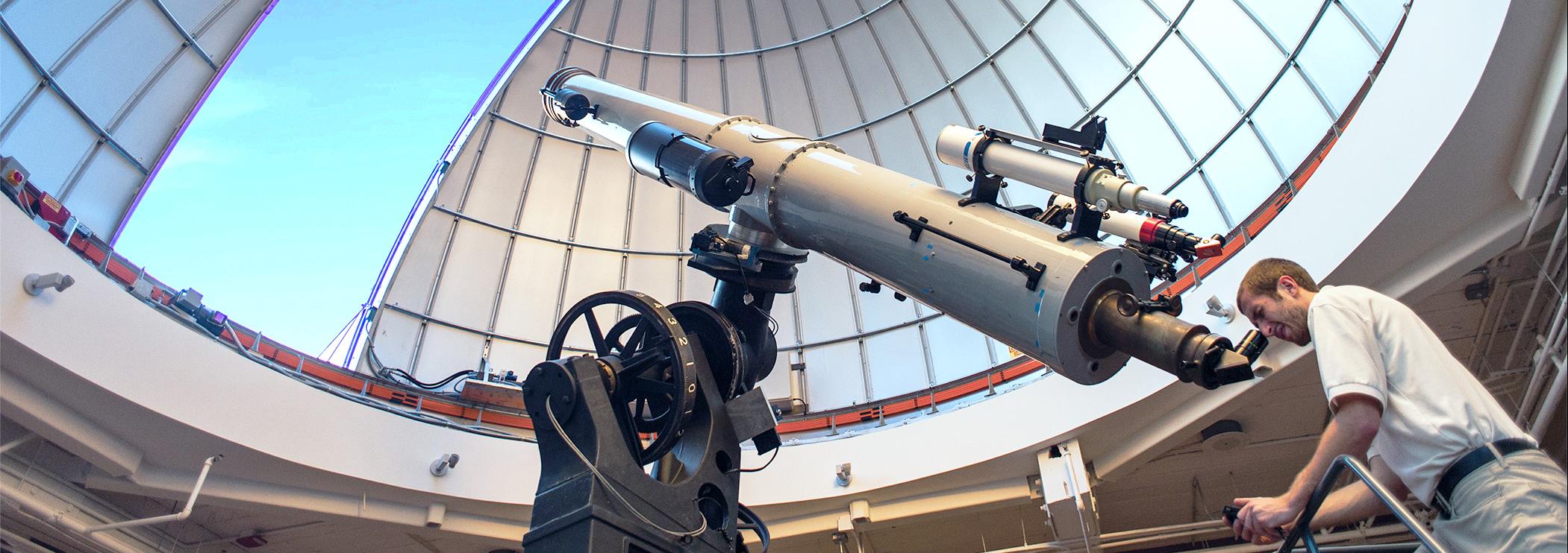 Observatory Educator Looks Through Alvan Clark Telescope During Solar Observing Hours With Dome Open Above Him Showing Blue Sky