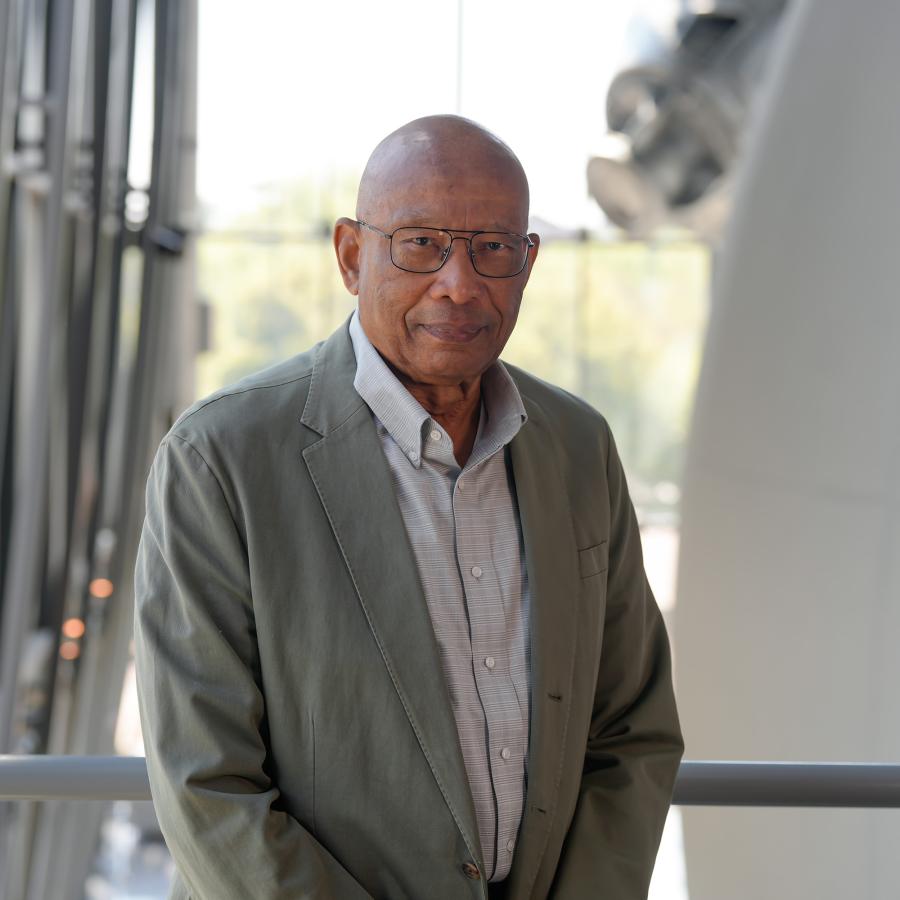 Man in gray suit jacket smiles at camera