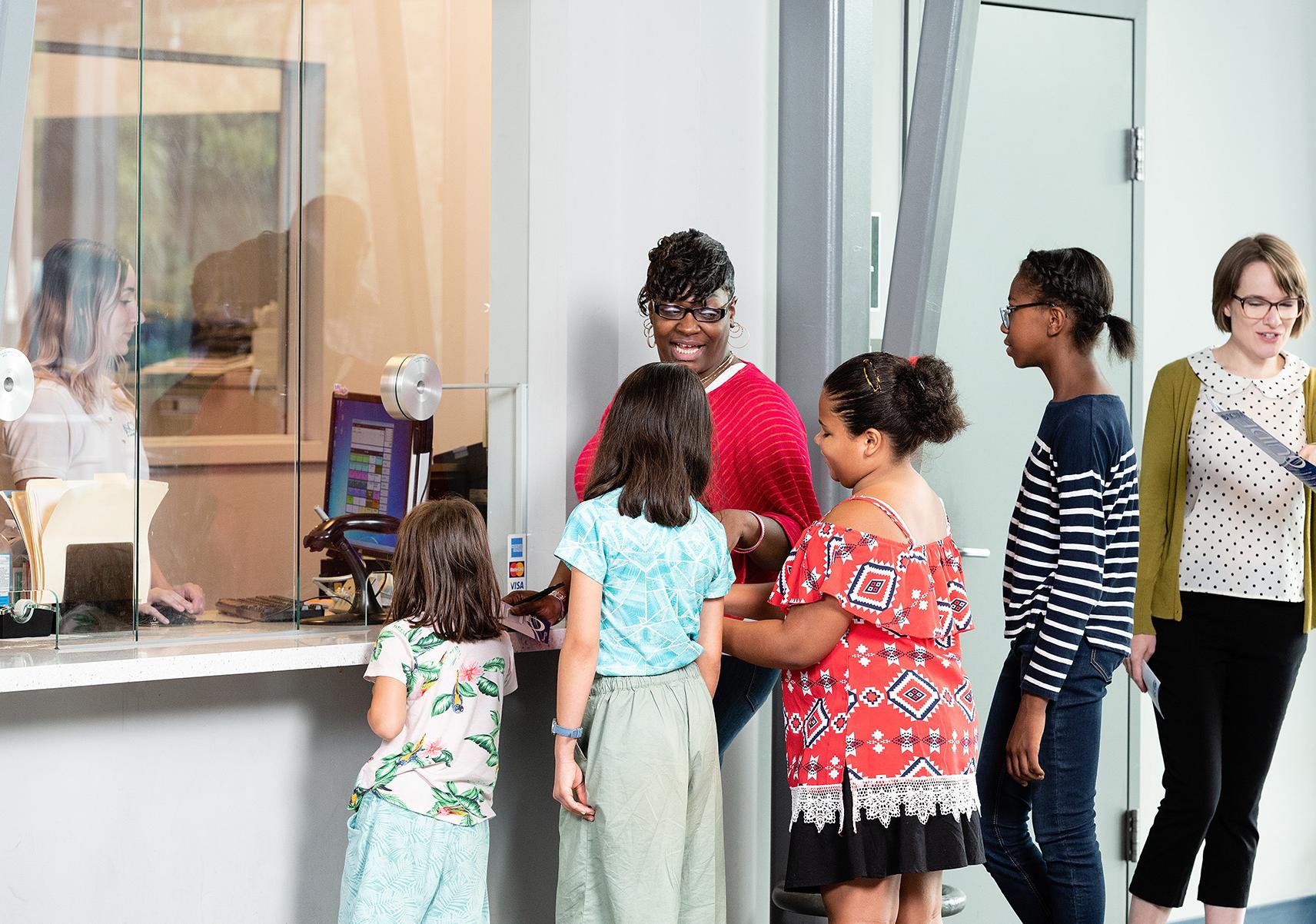 Students and chaperone wait in line at the Group Visits window