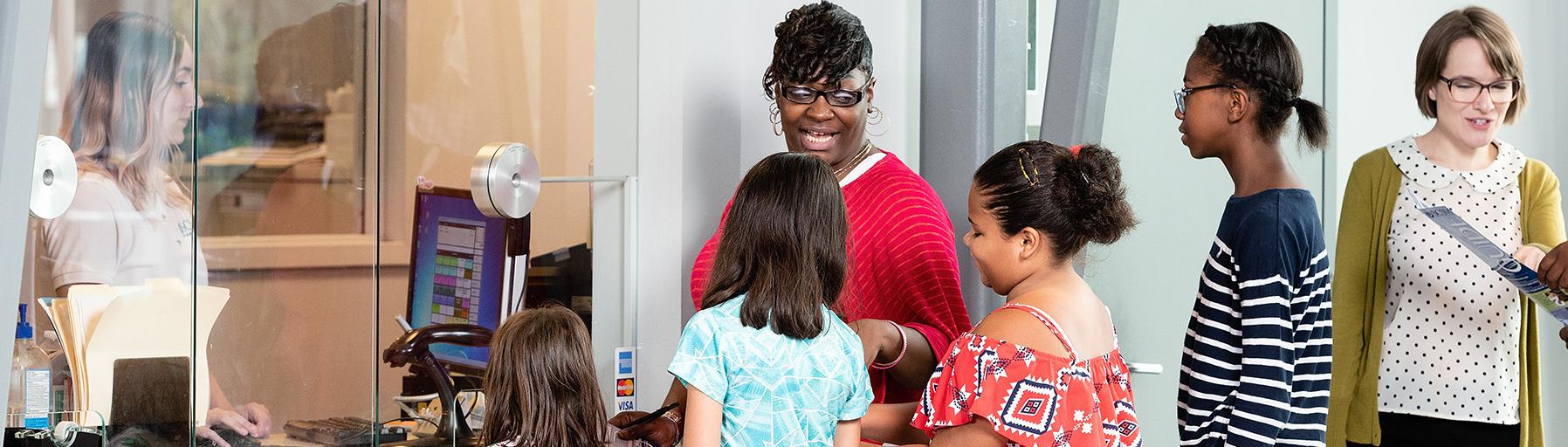 Students and chaperone wait in line at the Group Visits window