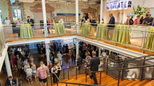 Wide image shows the museum's 2nd floor mezzanine overlooking the grand staircase down to the Main Lobby with reception guests 