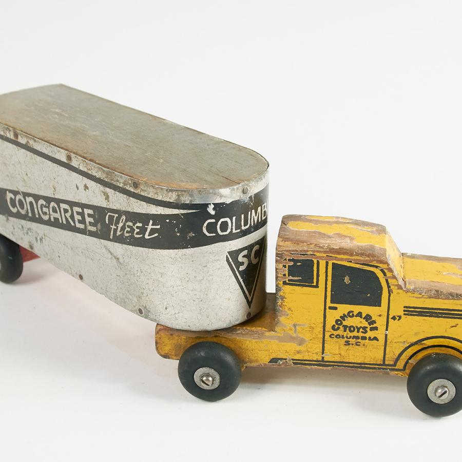 A toy truck with a yellow can and a trailer that says Congaree Fleet