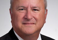 Man wearing dark suit, white shirt and red tie 
